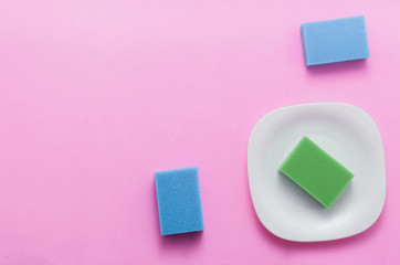 Concept of washing dishes on pastel pink background top view flat lay