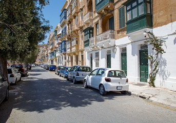 Cars parking lot next to the street. Old city street full with cars