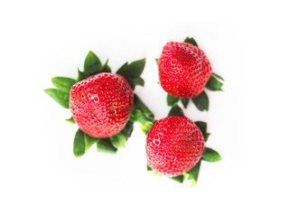 Three fresh ripe juicy garden strawberries isolated on white background. Green stem. Top view, close-up, macro. Edible, red fruit of the plant fragaria ananassa, rosaceae