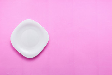 Single empty plate on pastel pink background top view flat lay copy space