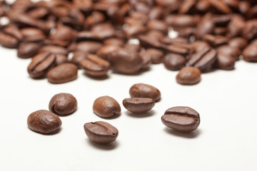 Spilled coffee beans on white background,