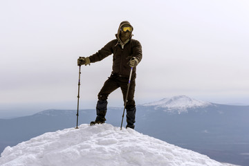 mountaineer in a windproof mask and glasses reached the snow top of the mountain