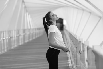 Sports woman in a white T-shirt while training on the bridge. Mock-up.