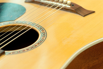 close up details of wooden acoustic guitars string