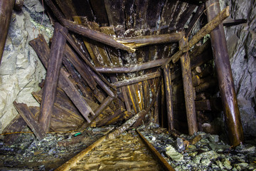 Underground abandoned gold ore mine shaft tunnel gallery with wooden timber