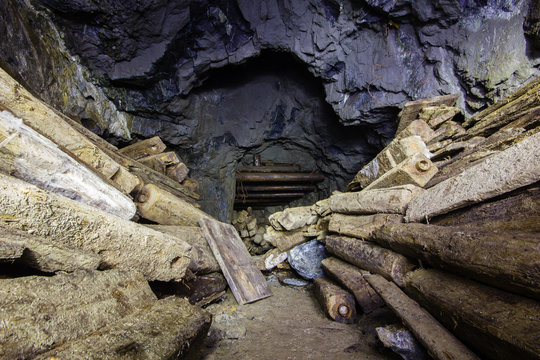 Underground abandoned gold ore mine shaft tunnel gallery with wooden timber
