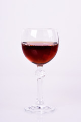 Extreme close up of crystal glass with red wine. Motion effect of wine.