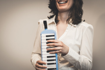 Someone is playing a melodica, also known as blow-organ, in vertical position. The hands are on the...