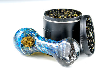 Close up of medical marijuana bud with a glass pipe and grinder