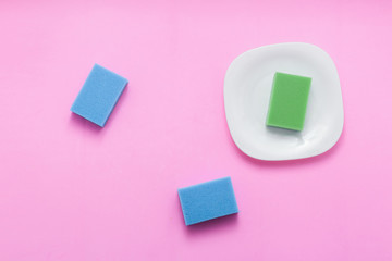 Concept of washing dishes on pastel pink background top view flat lay