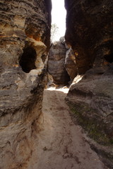 Obraz premium Walk way between grey and brown rocks.