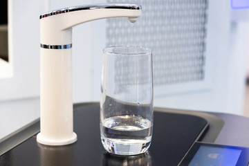 A glass of clean water under the filter closeup photo