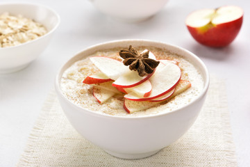 Oats porridge with red apple slices and cinnamon