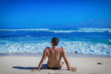 Fototapeta na wymiar Man lying and enjoying on a sandy tropical beach.
