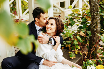 Romantic wedding moment, couple of newlyweds smiling portrait, bride and groom hug while on a walk in the park