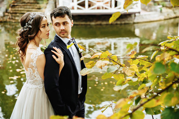 Romantic wedding moment, couple of newlyweds smiling portrait, bride and groom hug while on a walk...