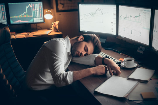 Young male trader at office work concept sitting sleeping