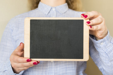 Young woman holding a chalk board in her hands