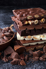Chocolate bars on dark background with chocolate tower