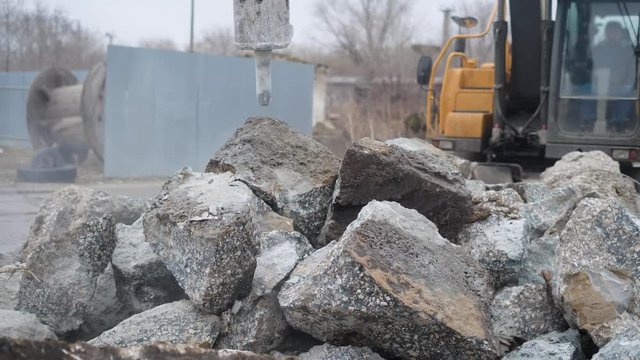 Big industrial heavy duty excavator cracking stones to gravel on construction site