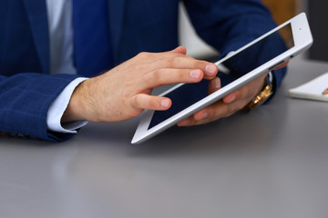 Businessman using touchpad at meeting, closeup of hands