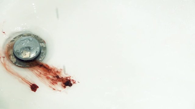 Splashes of blood dripping into the sink in the bathroom