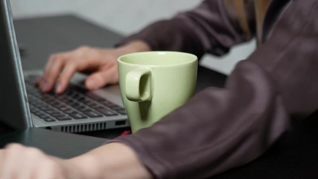 A woman poured tea onto a laptop. works in the office, 4k close-up,