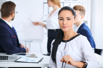 Obraz premium Business People at meeting in office. Focus at beautiful cheerful smiling woman. Conference, corporate training or brainstorming of people group. Success and negotiation concept