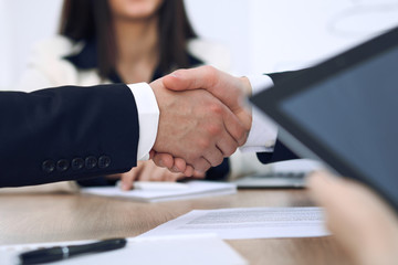 Obraz premium Close up of business people shaking hands at meeting or negotiation in the office. Partners are satisfied because signing contract
