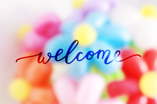 welcome lettering on blurred flowers background