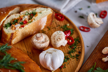 Delicious rustic pastries filled with herbs and vegetables on a wooden plate over a vintage background, selective focus