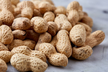 Pile of shelled peanuts isolated on white background, top view, close-up, vertical, shallow depth of field