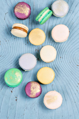 Close-up colorful French or Italian macaron on blue wooden table. Macarons is French dessert served with tea or coffee. wallpaper, Vertical photo