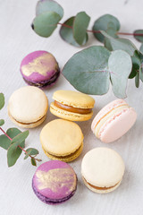 Close-up colorful French or Italian macaron on white wooden table. Macarons is French dessert served with tea or coffee. wallpaper, Vertical photo