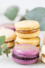 Close-up colorful French or Italian macaron on white wooden table. Macarons is French dessert served with tea or coffee. wallpaper, Vertical photo