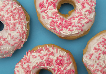White and Pink Sprinkle Donuts on a Blue Background