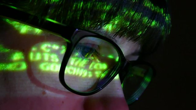 The programmer works at the computer over the program in a dark room. The hacker performs banned financial transactions with electronic money.