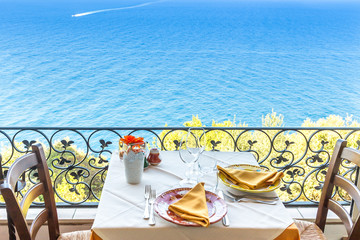 Restaurant table overlooking the sea on the Amalfi coast in Italy.