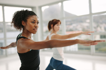 Fototapeta na wymiar Women performing yoga in fitness studio