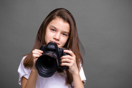 Cute brunette little girl holding an photo camera