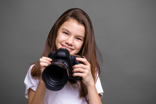 Cute brunette little girl holding an photo camera