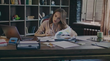 Attractive business woman reading documents at desk. Study of growth charts. Business process work in home office. Working woman analysing data. Market research concept. Marketer analyse market data - Powered by Adobe