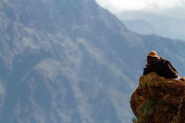 Tourist rests on the edge of a cliff of the Colca Canyon, in the province of Arequipa, Peru