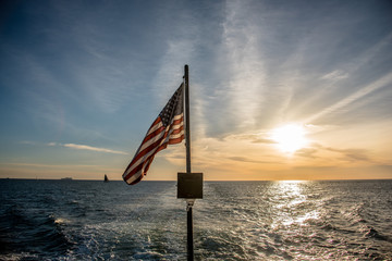 American flag flying from a sailboat at sea