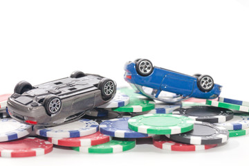 pile of casino chips and toy car on white background