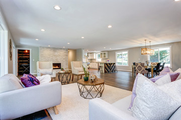 Spacious white living area with stone fireplace