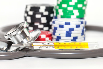 Thermometer and pile of casino chips on white background