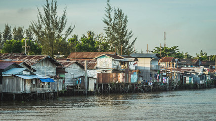 wooden house on the riverbank. slum area over the river. poverty and social problem concept