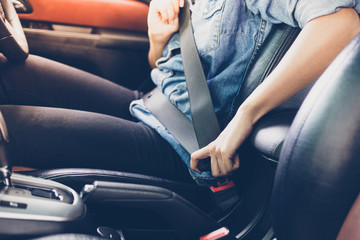 Asian woman fastening seat belt in the car, safety concept - Powered by Adobe