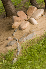 There is a stone flower of brown color in the city park. Summer